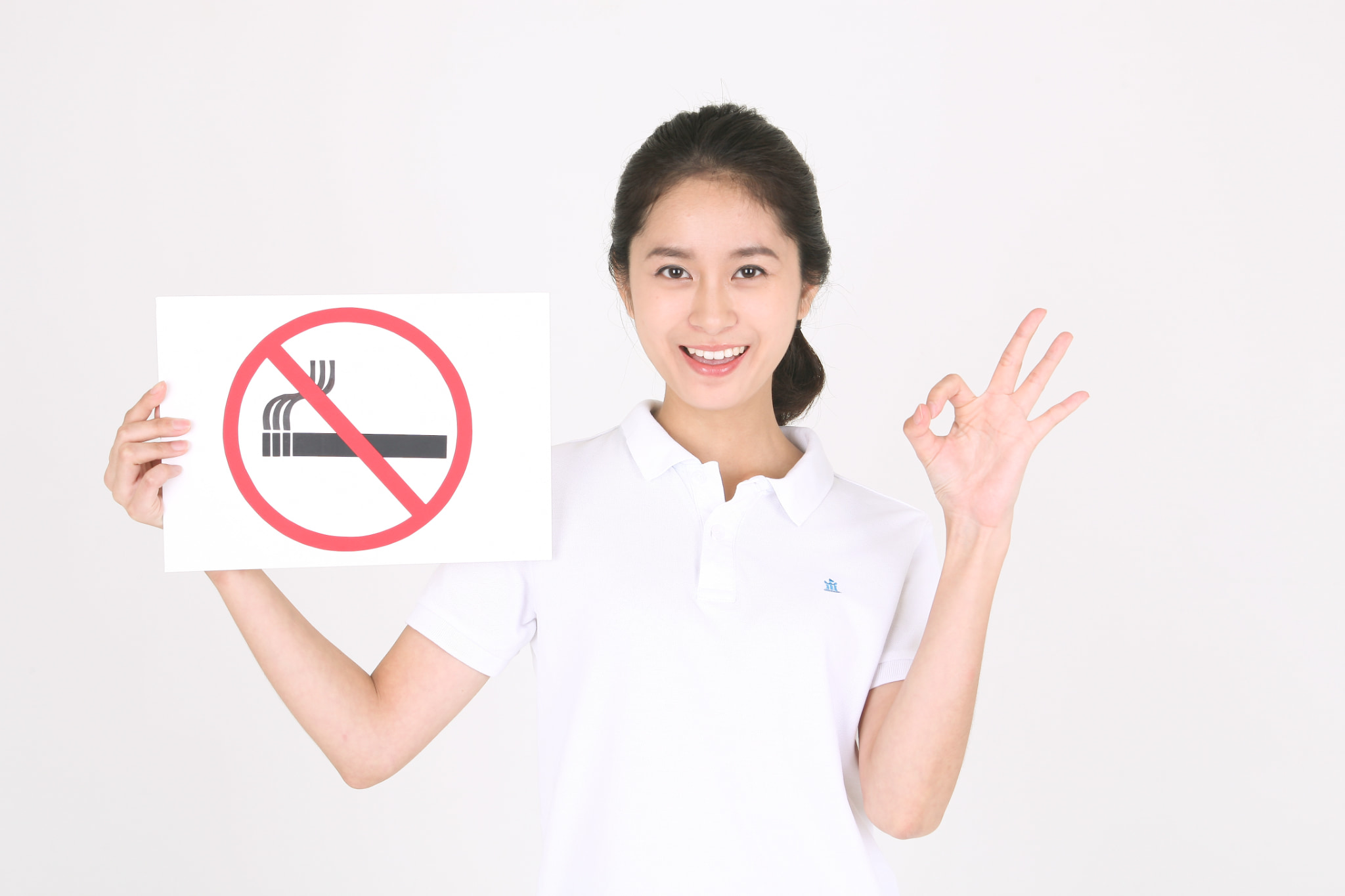 ホワイトニング後は喫煙がおすすめだという禁煙マークを持った女性