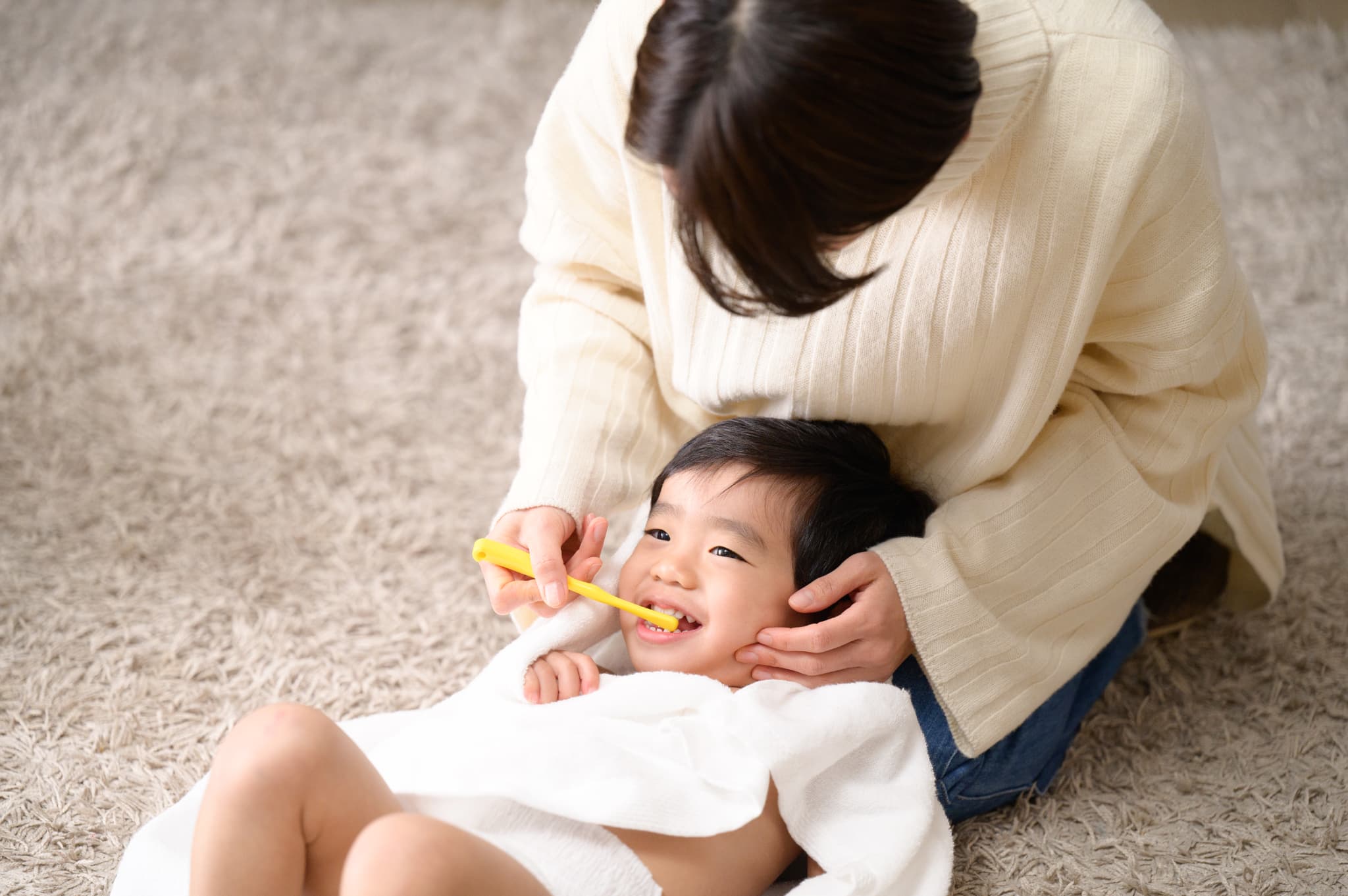 仕上げ磨きをしてもらう男の子