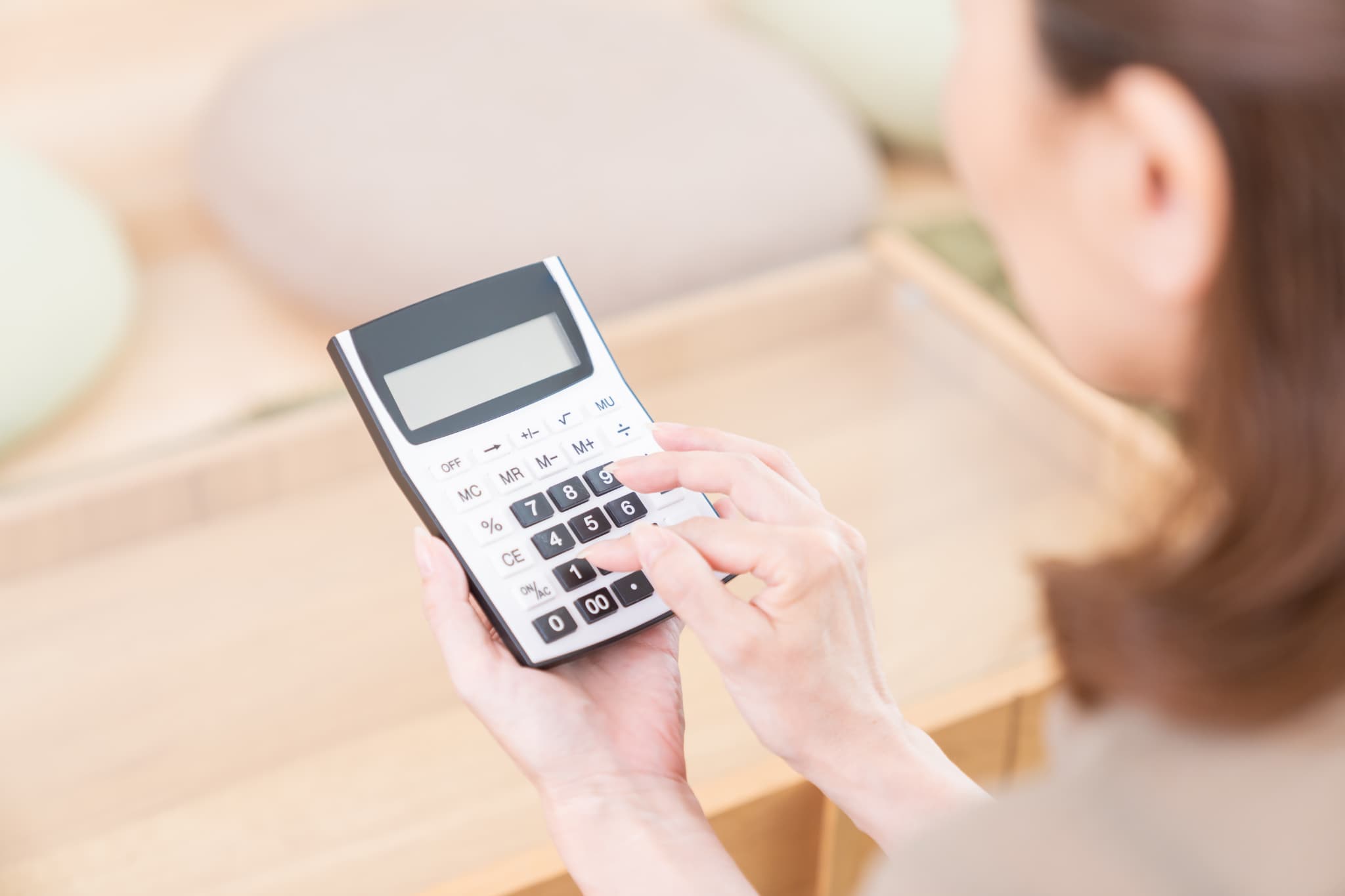 マウスピース矯正で八重歯を治す場合にかかる費用を計算する女性