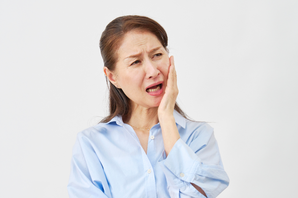 矯正治療中に痛みが生じている女性