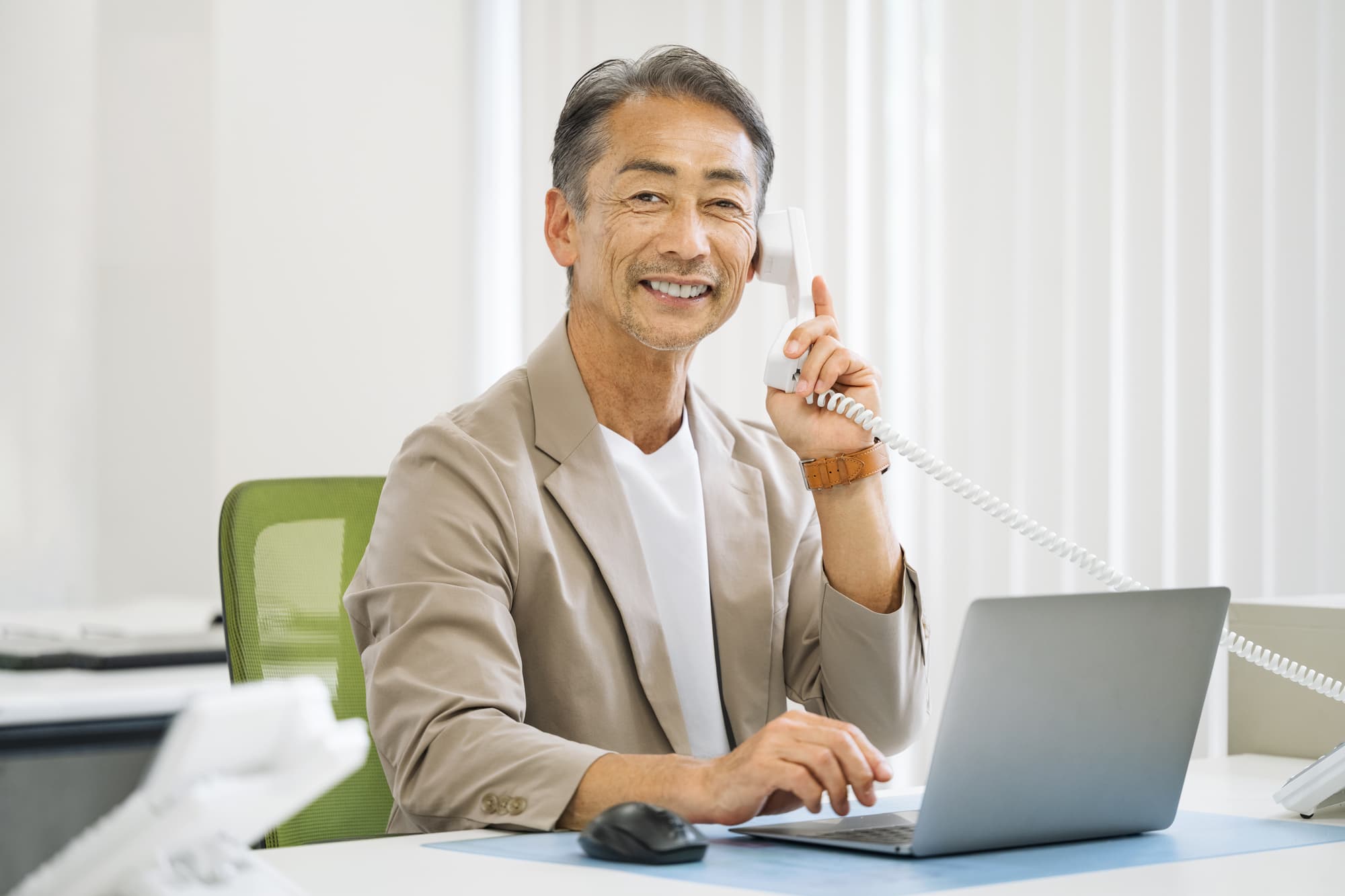 歯周病を予防して口臭のないミドル男性が電話をしているイメージ